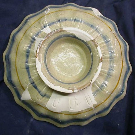 Restauro alzatina in maiolica con girali e clipeo centrale con figura di santo, fase dell'intervento; tipologia di restauro: mimetico antiquariale - Restoration riser in majolica with plant volutes and clypeus with central figure of a saint, step the intervention, type of restoration: invisible